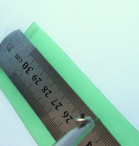Measuring a strip of plastic from a soda bottle.