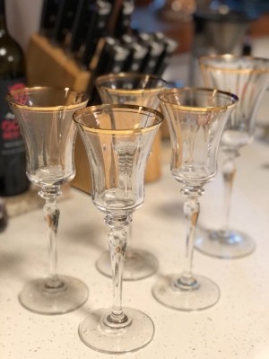 A collection of gold rimmed champagne flutes.