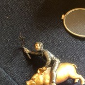 A figurine of a man riding a golden pig.