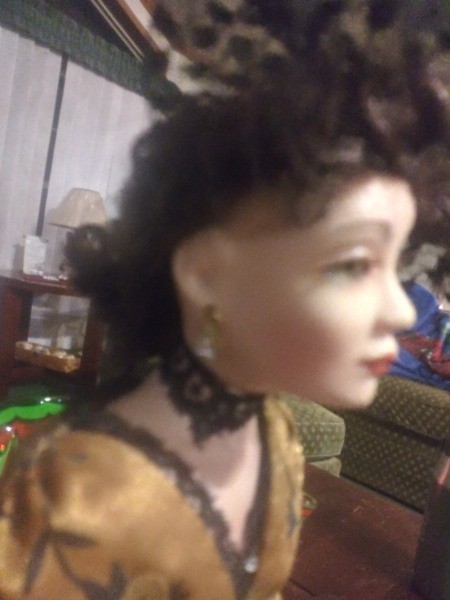 A side view of a fancy porcelain doll.