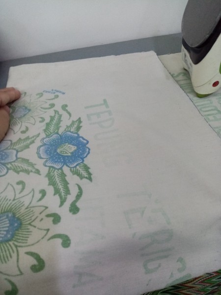Placing fabric on top of the item to be laminated.
