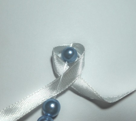 Adding ribbon between each bead.