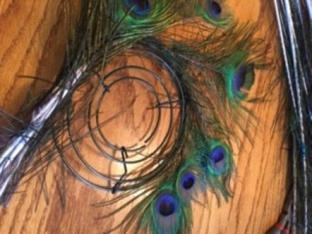 Adding peacock feathers to the wreath frame.