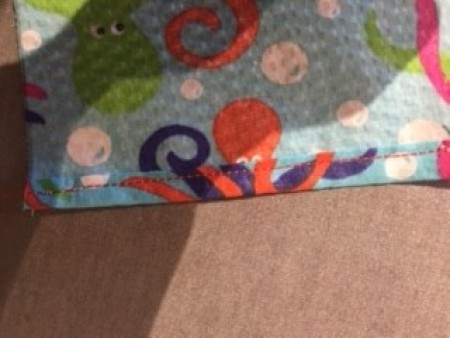 Sewing a seam on a square of fabric.