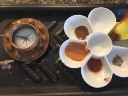 The painted compass next to the paint pallet.