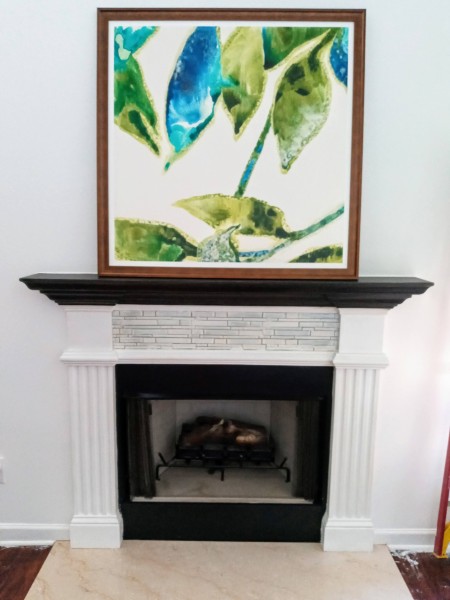 Fireplace with a large picture above.