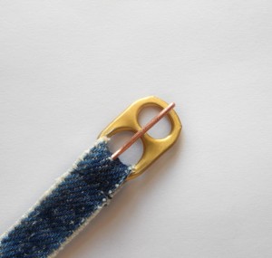 Attaching the tab to a strip of fabric to use as a buckle.
