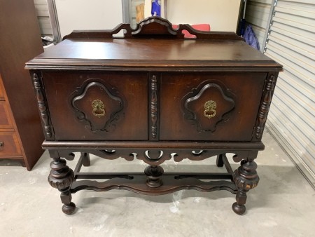 A wooden piece of furniture with cabinet doors.