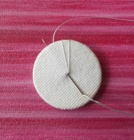 Adding stitches around the center of the brooch.