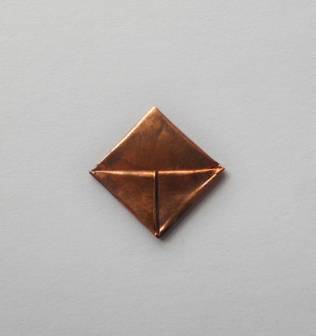 The folded square of copper.