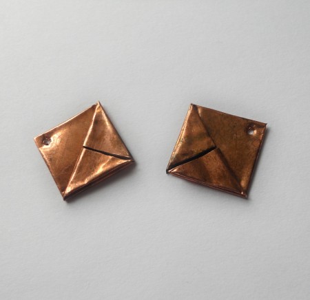 Two copper squares with holes at the top.