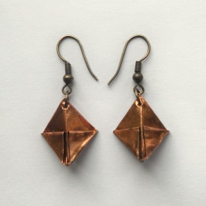 Two earrings made from copper foil.