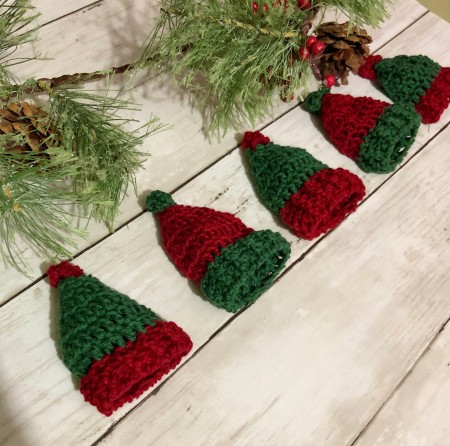 A garland of crocheted Christmas hats.
