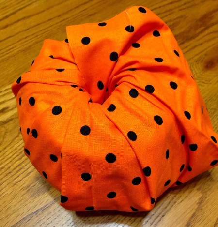 Tucking the fabric into the toilet paper roll.