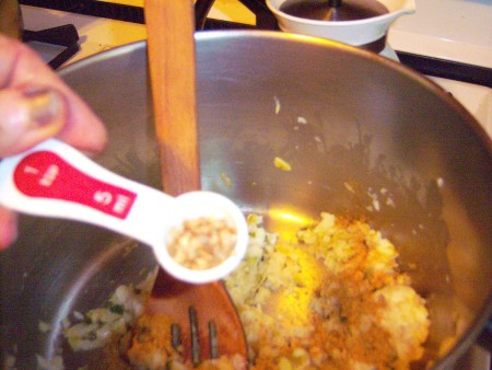 Adding spices to the soup pot.