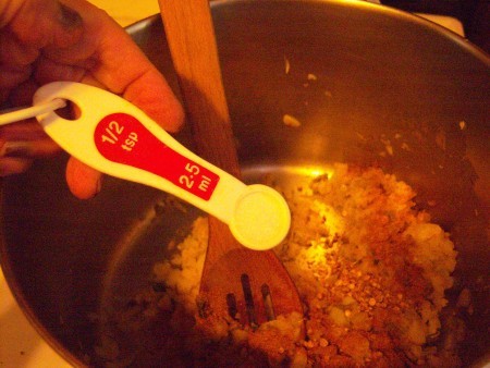 Adding spices to the soup pot.