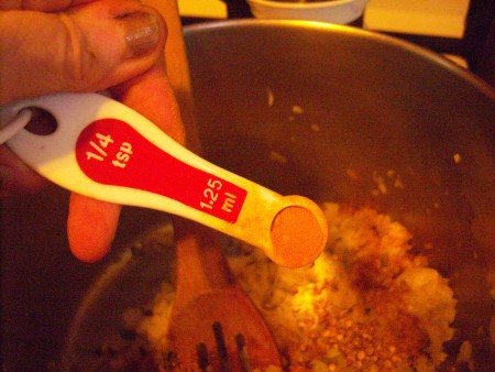 Adding spices to the soup pot.