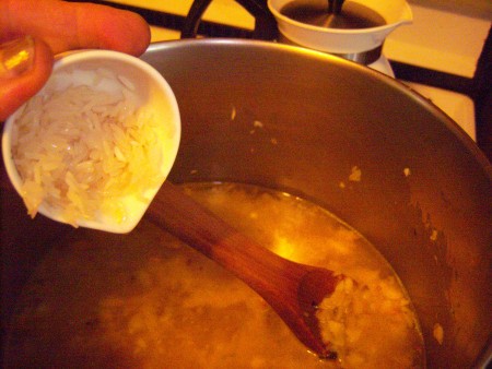 Adding rice to the soup pot.