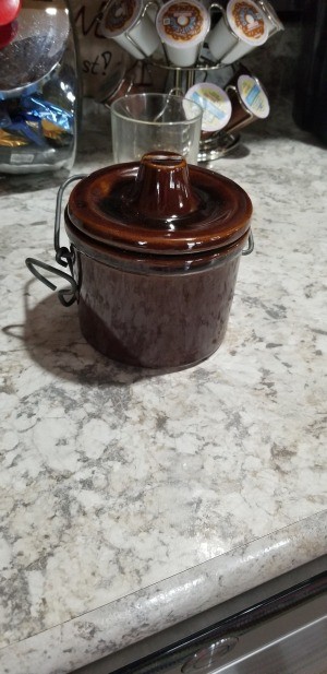 An old brown cheese crock.