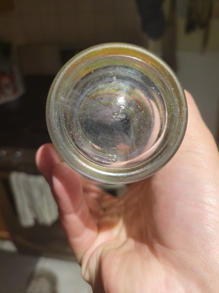 The bottom of a vintage drinking glass.