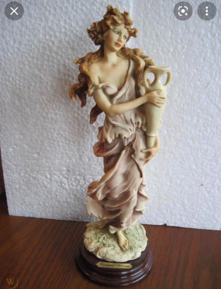 A figurine of a woman holding a vase.