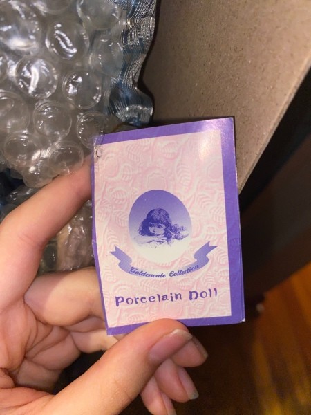 The tag on a porcelain doll.