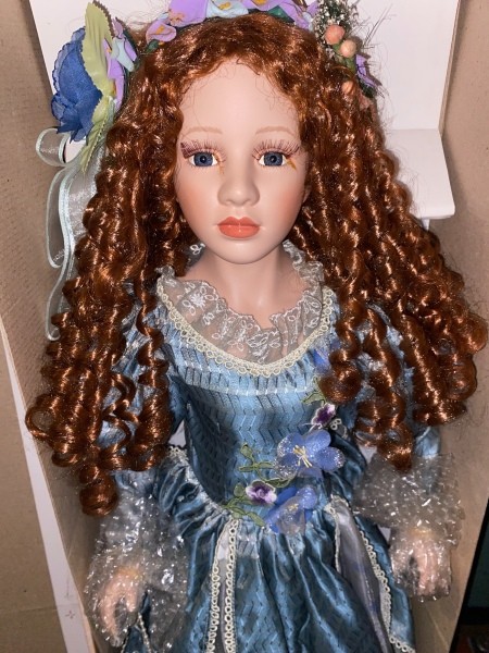 A porcelain doll with curly hair.