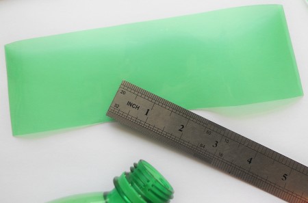 Measuring out a rectangle of green plastic.