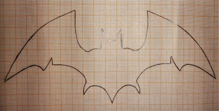 Tracing a bat silhouette on a piece of paper.