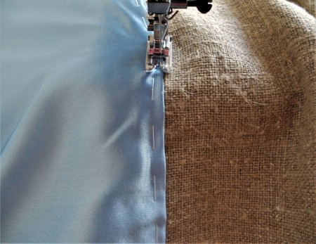 Sewing the burlap to the blue fabric.