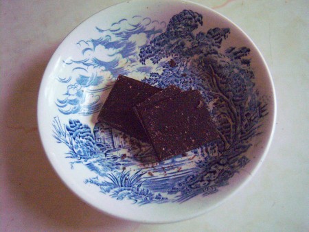 Placing squares of chocolate in a dish.