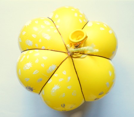 Rubber bands on a balloon to create a pumpkin shape.
