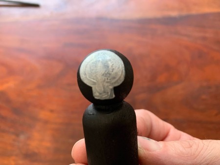 The skull shape painted on the peg doll.