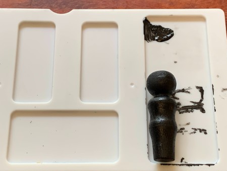 Painting the peg doll black.