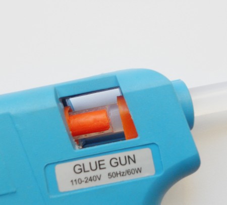 Putting the orange crayon and glue stick into the gun.