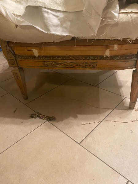 The wooden front of an armchair.