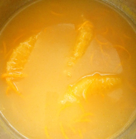 Adding the orange juice, peel and sections to the pan.