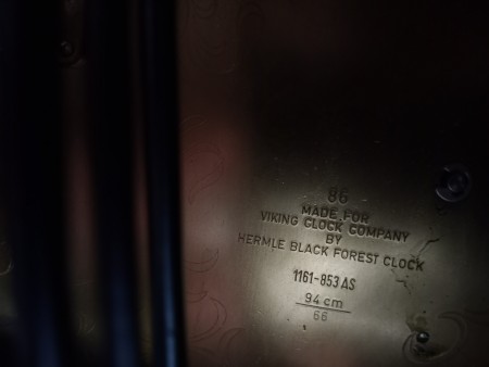 The manufacturer's information on the back of a grandfather clock.