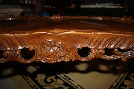 The carving on the side of a coffee table.