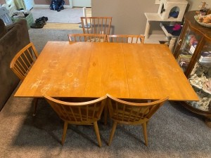 A wooden dining room set with 6 chairs.
