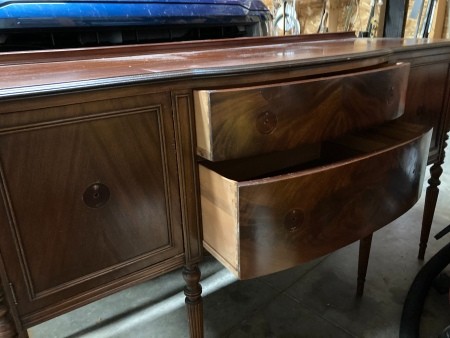 A wooden buffet with drawers and cabinets.