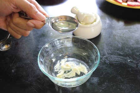 Adding fish sauce to the bowl.