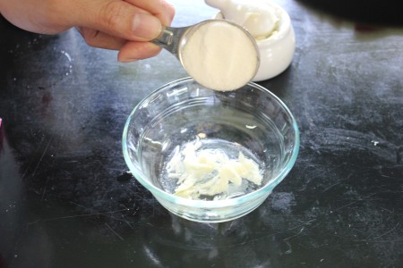Adding sugar to the bowl.