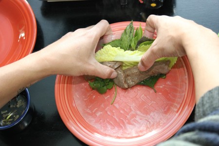 Rolling a filled spring roll.