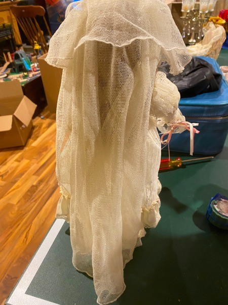 The back of a doll in a white dress.
