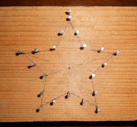 Making a star shaped frame with nails and wood.