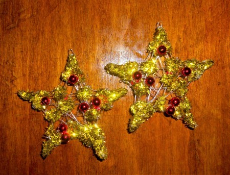 The completed glitter stars with small red ball ornaments attached.