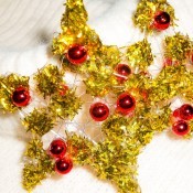 The completed glitter stars with small red ball ornaments attached.