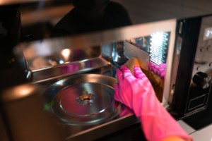 A gloved hand cleaning a microwave oven.