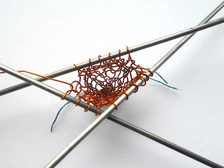 Knitting the copper wire into a heart.
